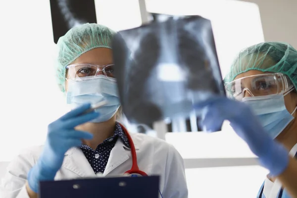 Los médicos están en la oficina y miran las radiografías. —  Fotos de Stock