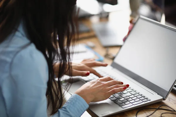 Frau sitzt am Tisch und arbeitet am Laptop — Stockfoto