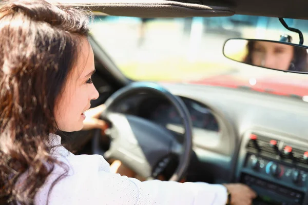 Junge brünette Frau sitzt hinterm Steuer des Autos — Stockfoto