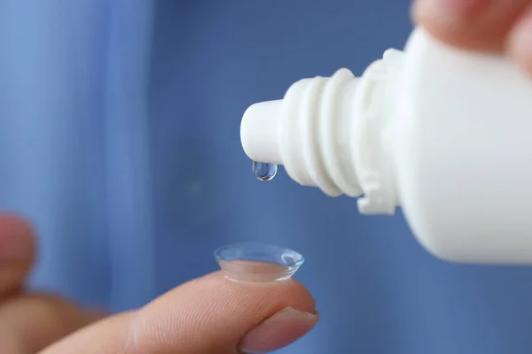 Woman drips liquid into contact lens for eyes closeup — Stock Photo, Image