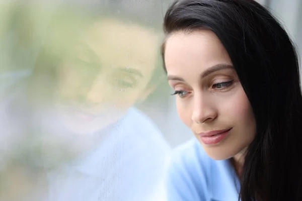 Pensive pensive girl sits alone and looks out window closeup — Stock Photo, Image