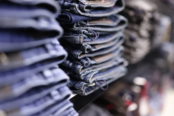 Stack of blue jeans in different shades at store closeup — Stock Photo, Image