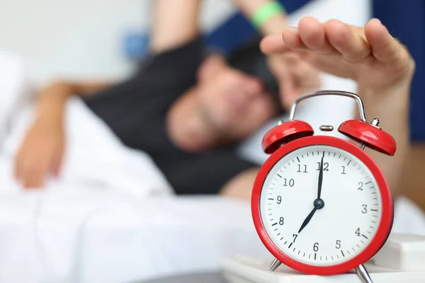 Rust man reikt naar horloge knop uit te schakelen dagelijks alarm en wakker worden — Stockfoto