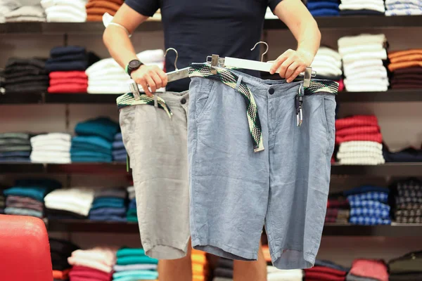 Athletic man chooses new shorts for summer closeup — Stock Photo, Image