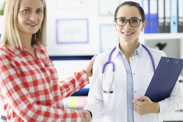 Female doctor hand shaking hand of patient and smiling — Stock Photo, Image