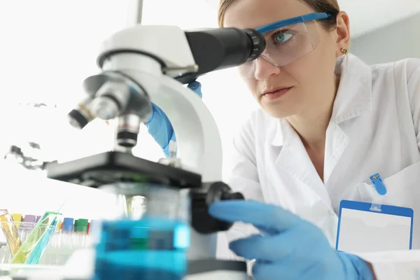 Portrait de femme scientifique regardant au microscope en laboratoire — Photo