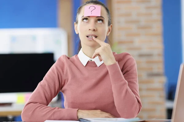 Pensiv kvinna på huvudet med klistermärke med frågetecken — Stockfoto