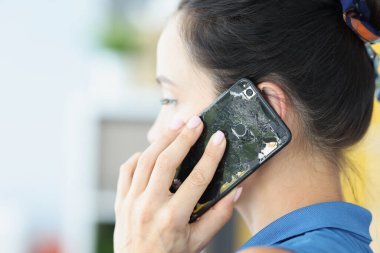 Kırık cep telefonuyla konuşan kadın, yakın plan.