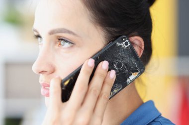 Kadın bozuk siyah akıllı telefondan konuşuyor. Yakın plan.