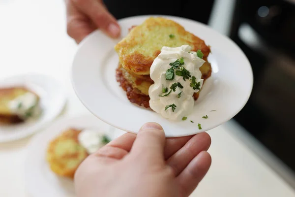 Chef servindo prato branco com panquecas de batata e creme de leite closeup — Fotografia de Stock