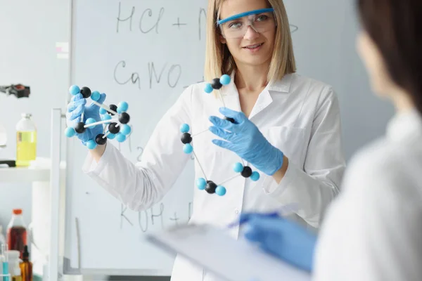 En manos de la mujer, el científico sostiene el modelo molecular en primer plano de laboratorio — Foto de Stock