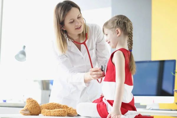 Médico pediatra ouve respiração e batimento cardíaco com estetoscópio de menina. — Fotografia de Stock