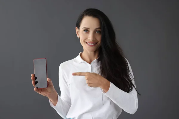Glimlachend portret van vrouw met smartphone in de hand — Stockfoto