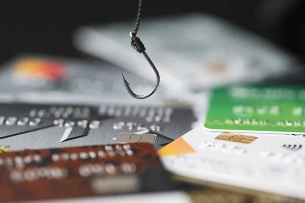 Haak en credit plastic bankkaarten op tafel closeup — Stockfoto