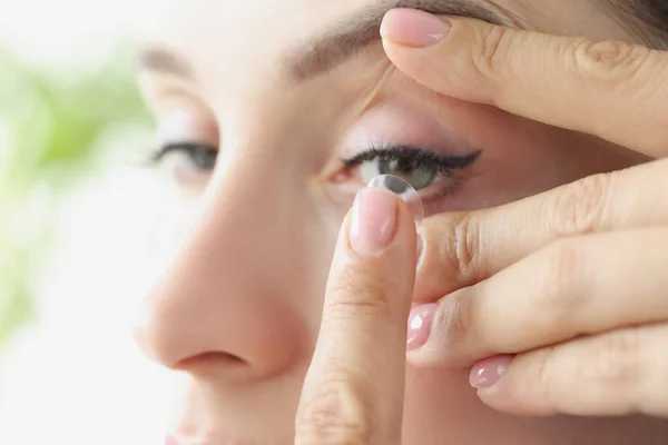Jonge vrouw zet zachte contactlenzen op oog close-up — Stockfoto