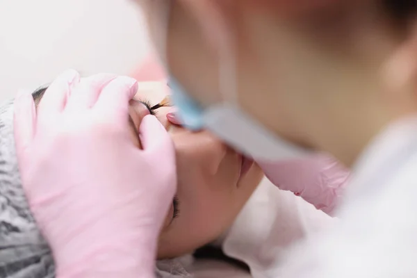 Master maakt permanente make-up voor oogleden van de klant in salon — Stockfoto