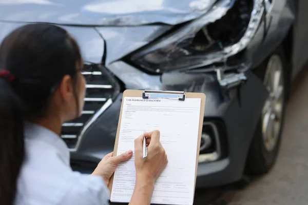 Versicherungsvertreterin füllt Versicherungsformular für Autoschäden nach Verkehrsunfall aus — Stockfoto