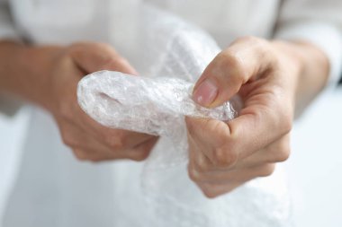 Kadın elleri plastik poşeti ezer.