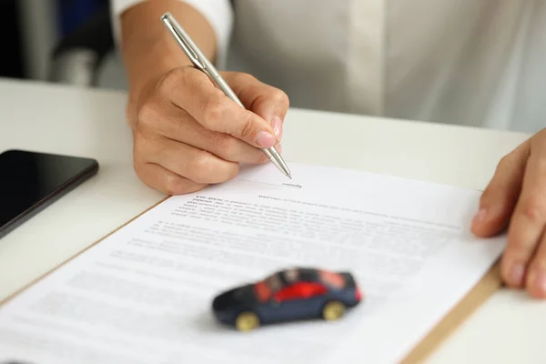Frau unterschreibt Kaufvertrag für Auto auf Kredit — Stockfoto