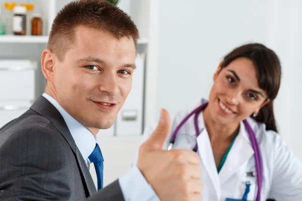 Affärsman visar tummen med läkare — Stockfoto