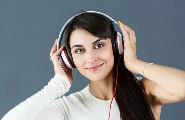 Bela mulher de cabelos escuros sorrindo usando fones de ouvido — Fotografia de Stock