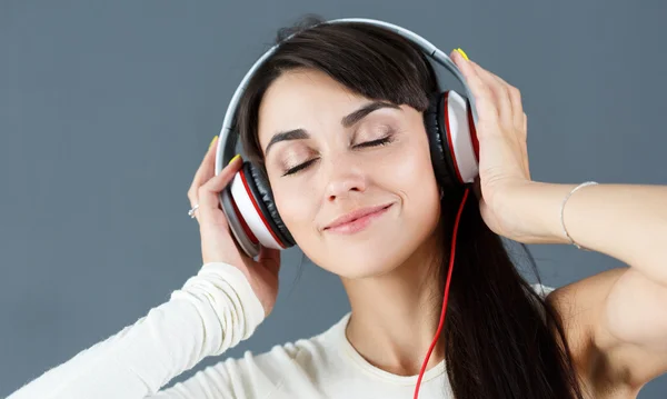 Bela mulher de cabelos escuros sorrindo usando fones de ouvido — Fotografia de Stock