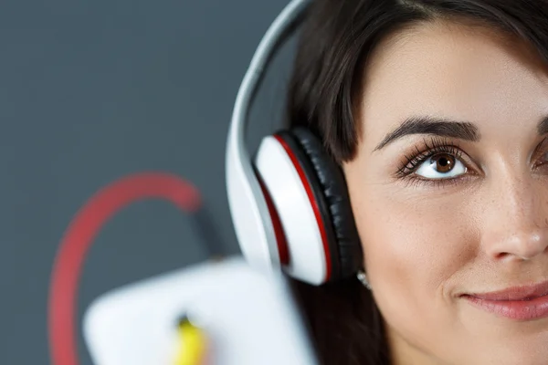 Beautiful dark haired smiling woman wearing headphones — Stock Photo, Image