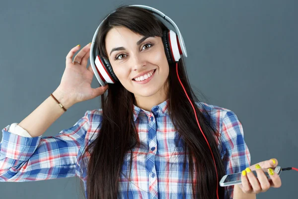 Bela mulher de cabelos escuros sorrindo usando fones de ouvido — Fotografia de Stock