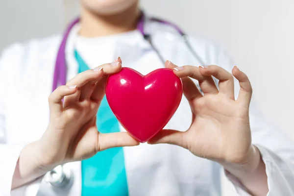 Female medicine doctor hands holding toy heart — Stock Photo, Image