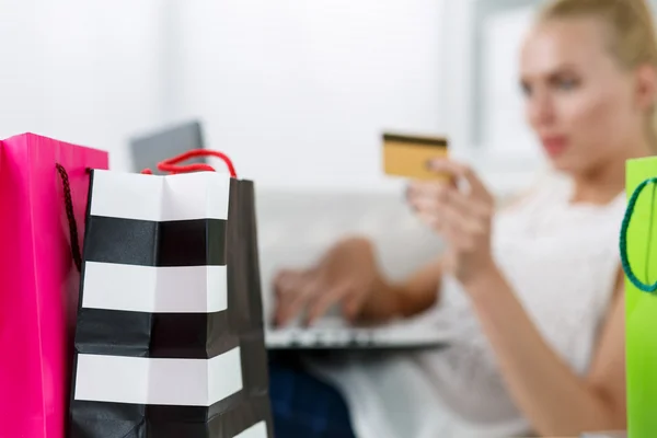 Mujer rubia haciendo compras vía internet pagando con tarjeta de crédito —  Fotos de Stock