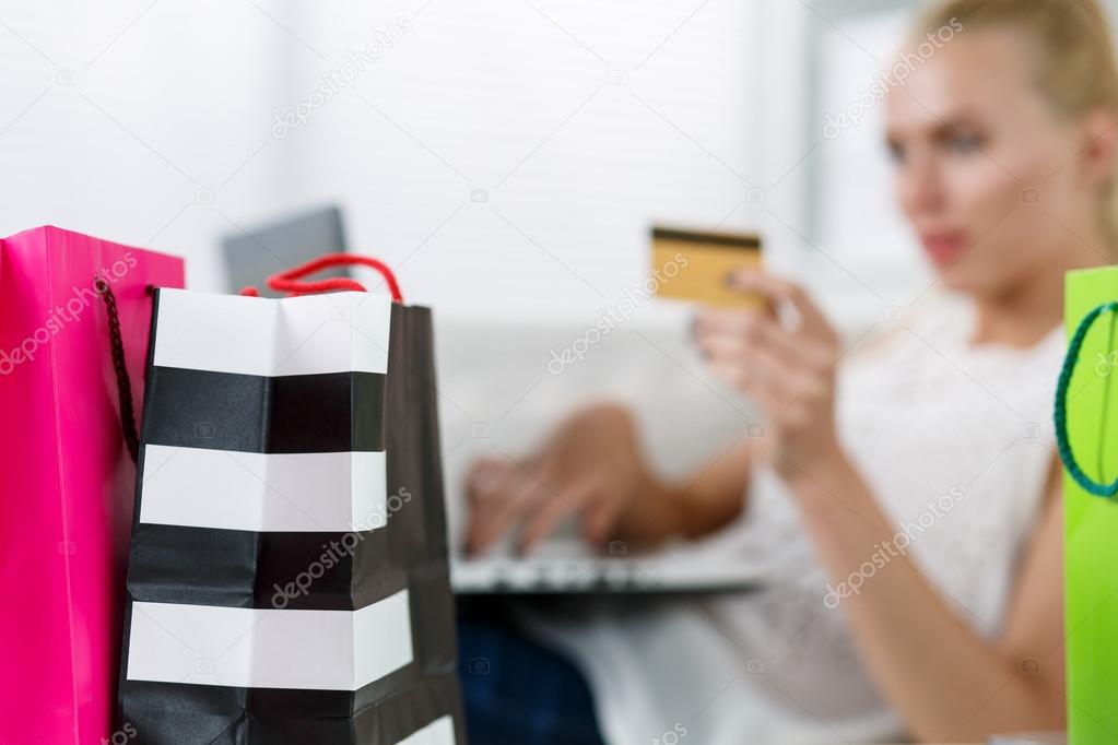 Blond woman making purchasing via internet paying credit card
