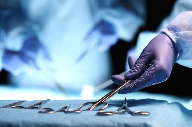 Nurse hand taking surgical instrument 