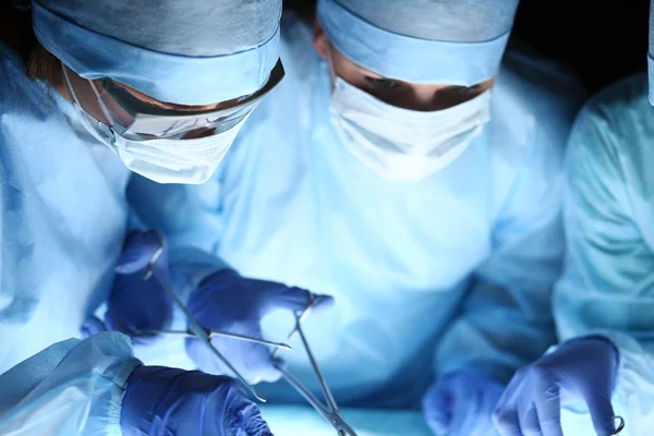 Group of surgeons at work operating in surgical theatre — Stock Photo, Image