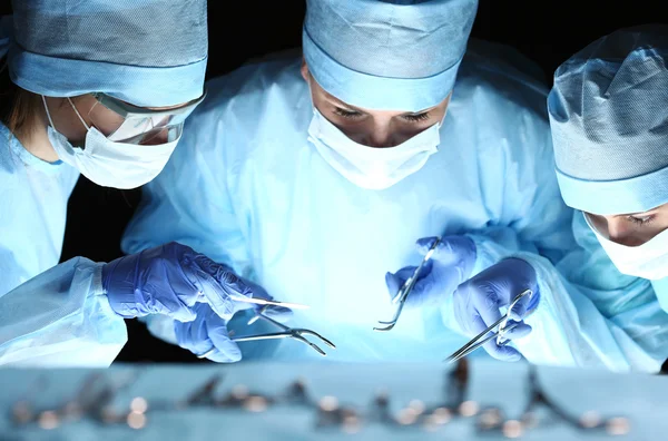 Groupe de chirurgiens au travail opérant en salle d'opération — Photo