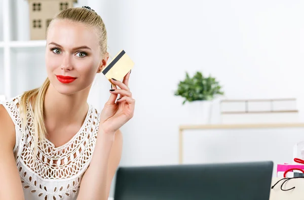 Mulher loira bonita segurando cartão de crédito dourado — Fotografia de Stock