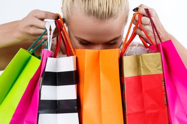 Blond woman inspecting content of colored paper bags with fresh — Stock Photo, Image