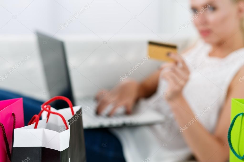 Blond woman making purchasing via internet paying credit card