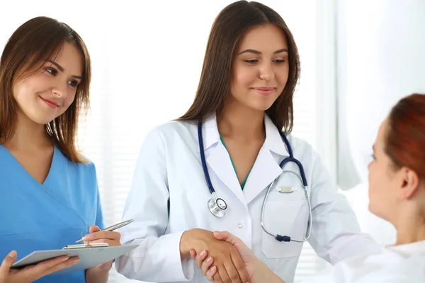 Medico femminile che stringe la mano al paziente sdraiato a letto — Foto Stock