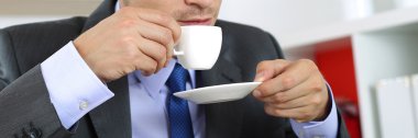 Businessman in suit drinking hot fresh morning cup of coffee