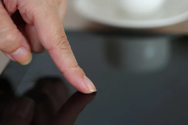 Mano femminile che punta in pc tablet nero — Foto Stock