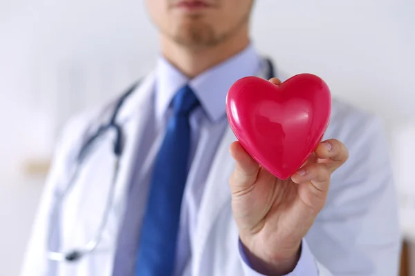 Αρσενική ιατρική γιατρός χέρια που κρατούν την καρδιά κόκκινο παιχνίδι — Φωτογραφία Αρχείου