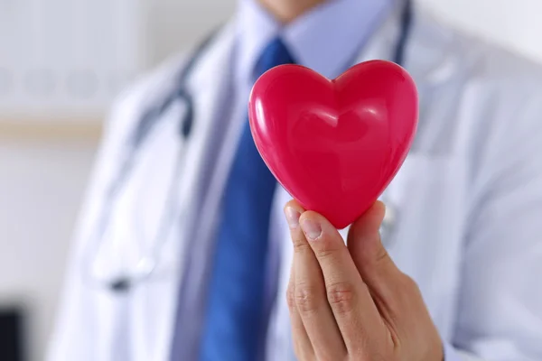 Male medicine doctor hands holding red toy heart — Stock Photo, Image