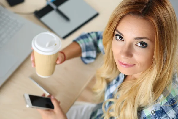 Female designer in office drinking morning tea — Zdjęcie stockowe