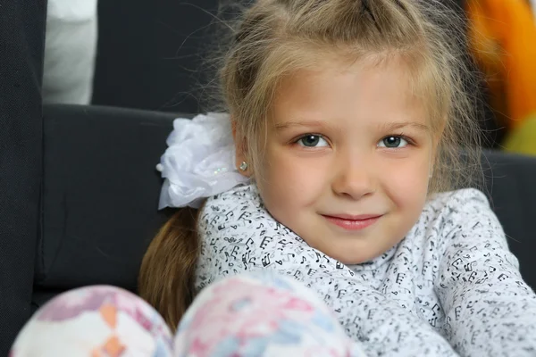 Nachdenkliches blondes kleines Mädchen auf dem Boden sitzend — Stockfoto