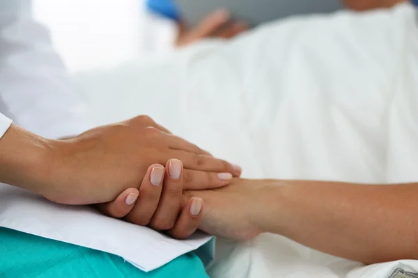 Przyjazne doktora kobiece ręce trzymając rękę pacjenta — Zdjęcie stockowe