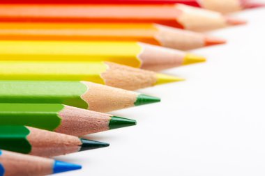Set of multicoloured pencils lying on white table