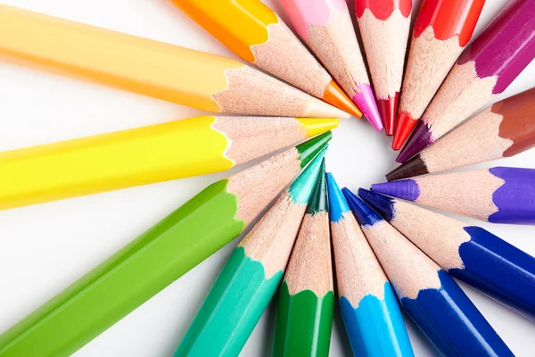 Set of multicoloured pencils lying on white table round order — Stockfoto