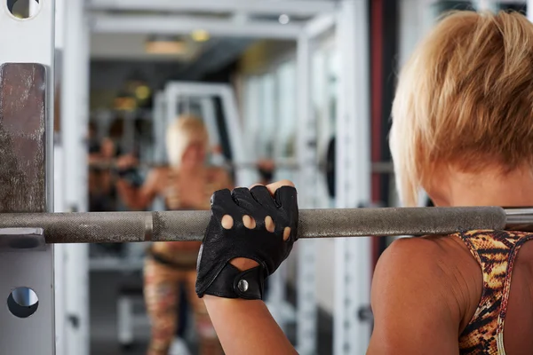 Hand van blonde vrouw atleet maken squats — Stockfoto