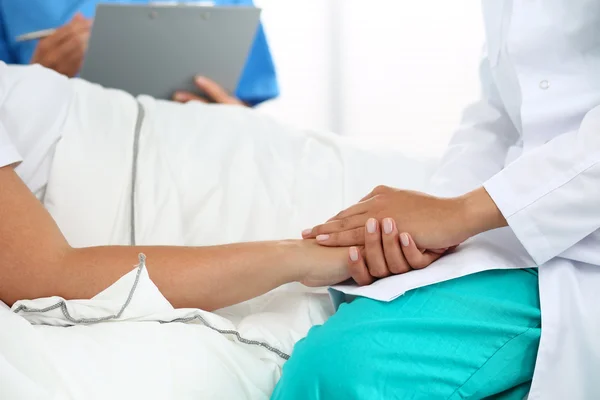 Amistosa mujer médico manos sosteniendo paciente mano — Foto de Stock