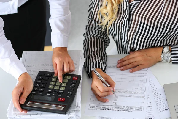Two female accountants counting on calculator — Φωτογραφία Αρχείου